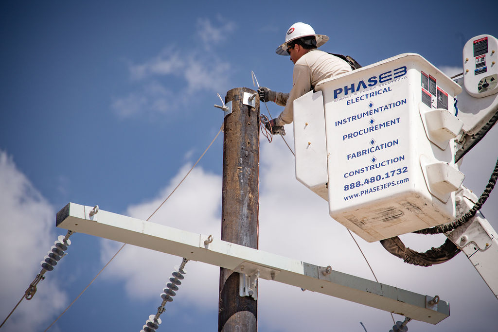 Phase 3 crew member on a bucket hooking cables